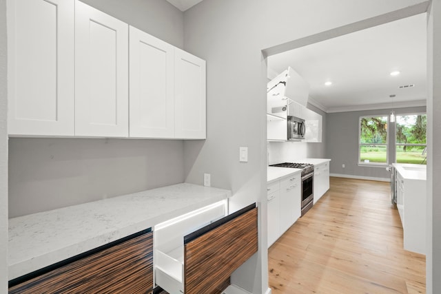 kitchen featuring light stone countertops, light hardwood / wood-style flooring, stainless steel appliances, and white cabinets