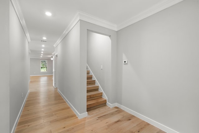 hallway featuring ornamental molding and light wood-type flooring