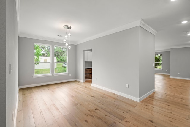 unfurnished room featuring ornamental molding and light wood-type flooring