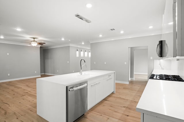 kitchen with pendant lighting, white cabinetry, sink, stainless steel appliances, and a center island with sink