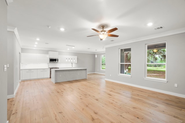 unfurnished living room with ceiling fan, ornamental molding, sink, and light hardwood / wood-style floors