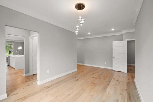 spare room featuring ornamental molding, sink, and light hardwood / wood-style floors