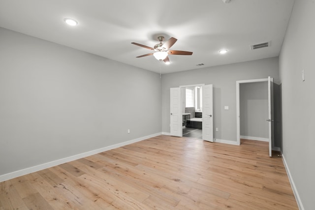 unfurnished bedroom with ensuite bath, light hardwood / wood-style floors, and ceiling fan