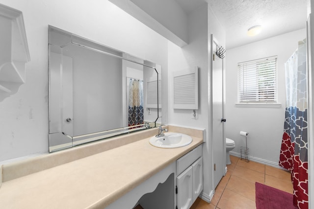 bathroom with tile patterned floors, toilet, a textured ceiling, and vanity