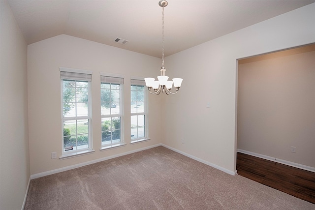 spare room featuring vaulted ceiling, carpet, and an inviting chandelier