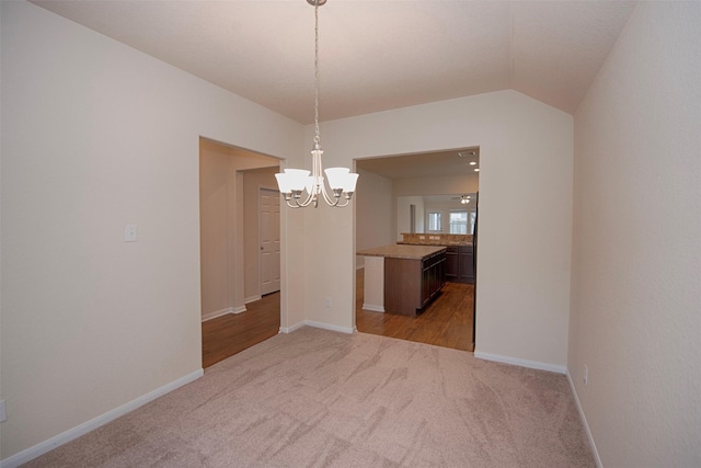 unfurnished dining area featuring lofted ceiling, light colored carpet, and a chandelier