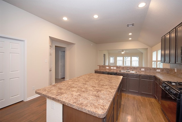 kitchen featuring a kitchen island, dark hardwood / wood-style floors, lofted ceiling, sink, and black range with gas cooktop