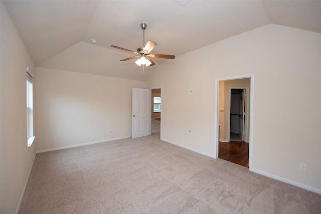 carpeted spare room featuring ceiling fan and lofted ceiling