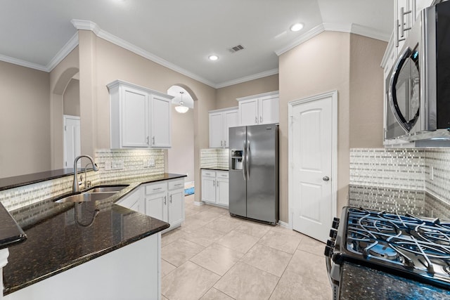 kitchen with sink, dark stone countertops, white cabinets, backsplash, and stainless steel appliances