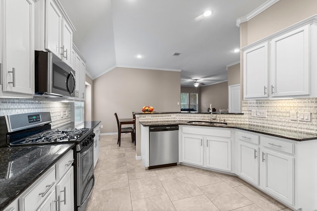 kitchen with sink, vaulted ceiling, stainless steel appliances, and white cabinets