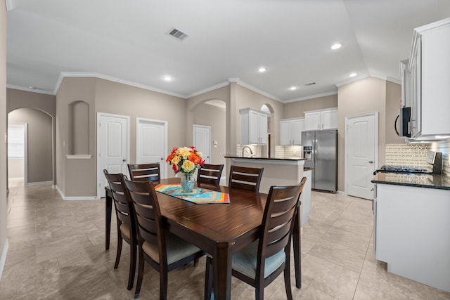 dining area featuring lofted ceiling and crown molding