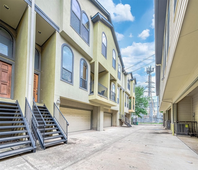 view of building exterior with central AC unit and a garage