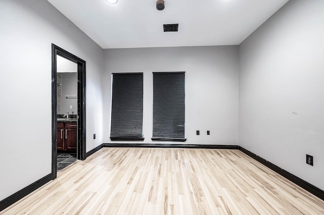 empty room featuring sink and light hardwood / wood-style floors