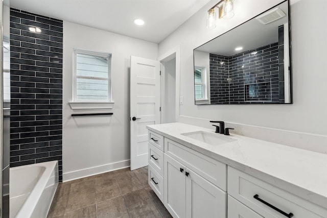 bathroom featuring vanity and tiled shower / bath