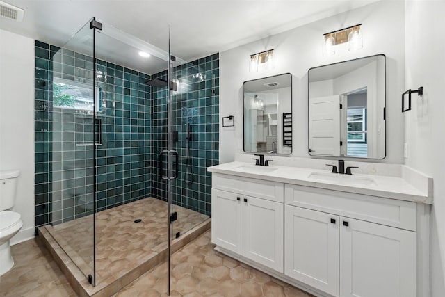 bathroom with tile patterned floors, toilet, a shower with shower door, and vanity