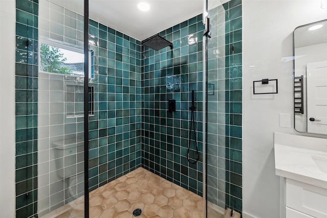 bathroom with vanity, tile patterned flooring, and a tile shower