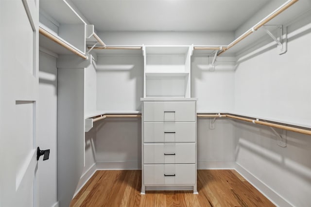 walk in closet with light hardwood / wood-style floors