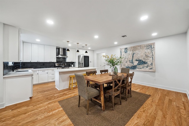 dining room with sink and light wood-type flooring