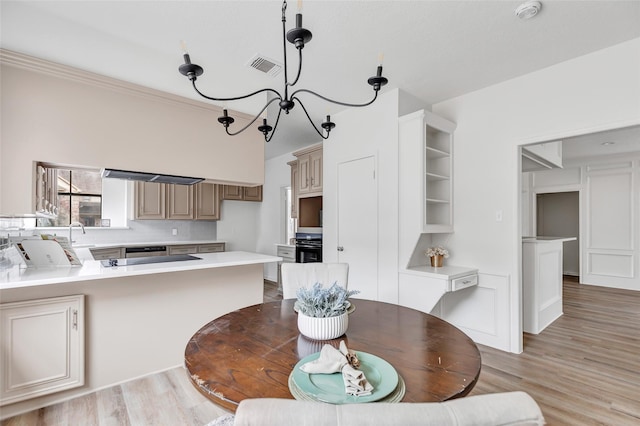 dining room featuring sink, an inviting chandelier, and light hardwood / wood-style flooring