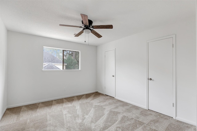 unfurnished bedroom with light carpet and ceiling fan