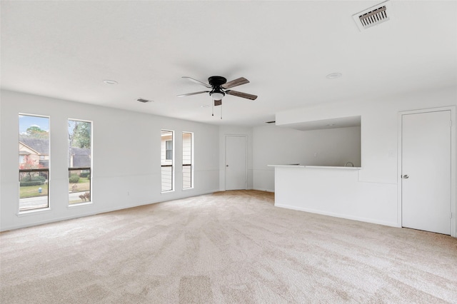 unfurnished living room featuring ceiling fan and light colored carpet