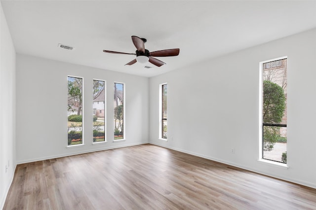 unfurnished room featuring plenty of natural light, ceiling fan, and light hardwood / wood-style flooring