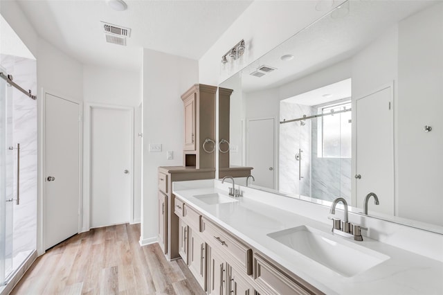 bathroom with vanity, hardwood / wood-style floors, and an enclosed shower