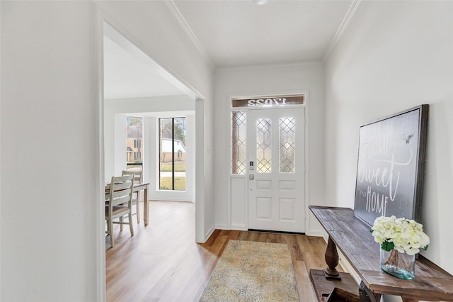 entryway featuring ornamental molding and light hardwood / wood-style flooring