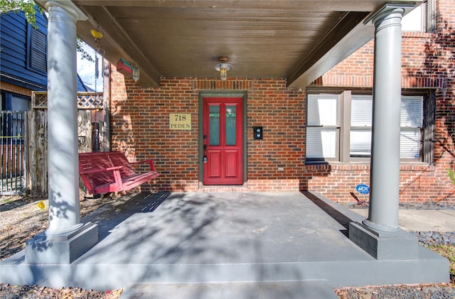 view of exterior entry featuring covered porch