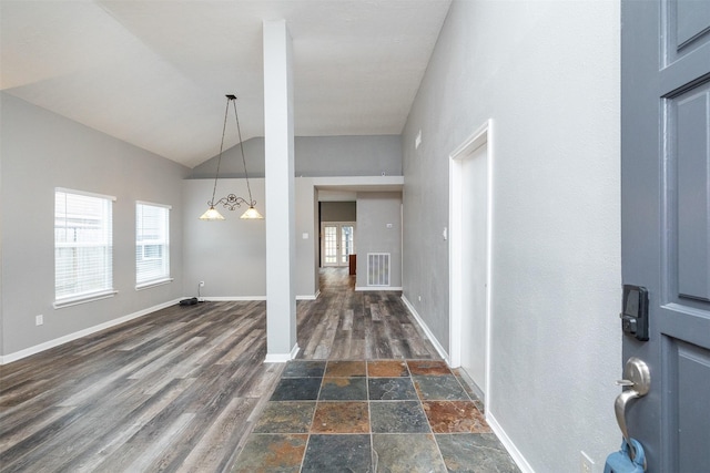 entrance foyer featuring lofted ceiling, a wealth of natural light, and dark hardwood / wood-style flooring