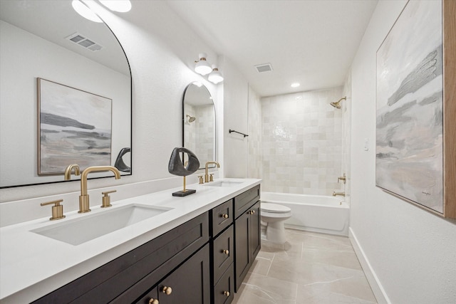 full bathroom featuring tiled shower / bath, vanity, and toilet