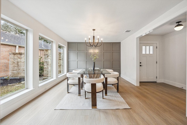 dining room featuring light hardwood / wood-style floors, a chandelier, and a healthy amount of sunlight