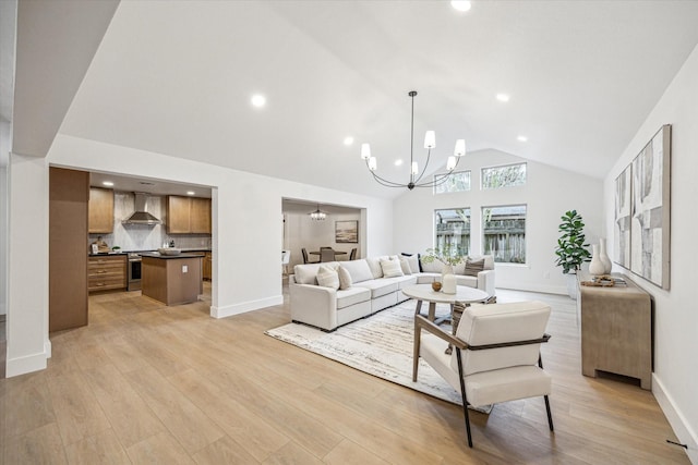 living room featuring high vaulted ceiling, a chandelier, and light hardwood / wood-style flooring