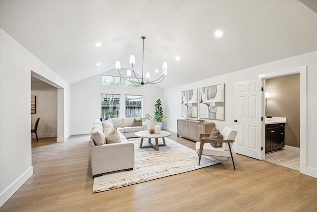 living room with an inviting chandelier, high vaulted ceiling, and light wood-type flooring