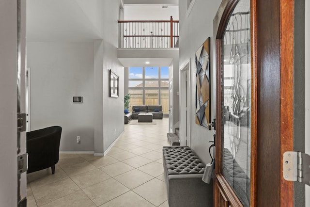 tiled foyer entrance featuring a towering ceiling