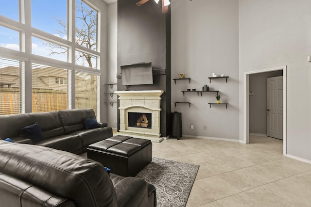 tiled living room with a towering ceiling, plenty of natural light, and ceiling fan