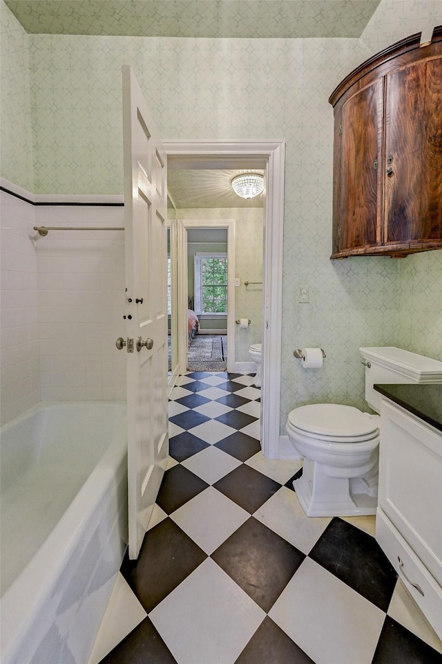 bathroom with vanity, a bathtub, and toilet