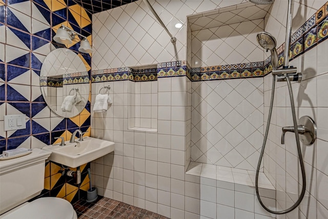 bathroom with tile walls, sink, toilet, and a tile shower