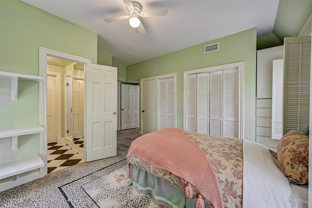 bedroom with lofted ceiling, two closets, and ceiling fan