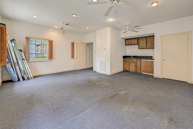 unfurnished living room with dark colored carpet and ceiling fan