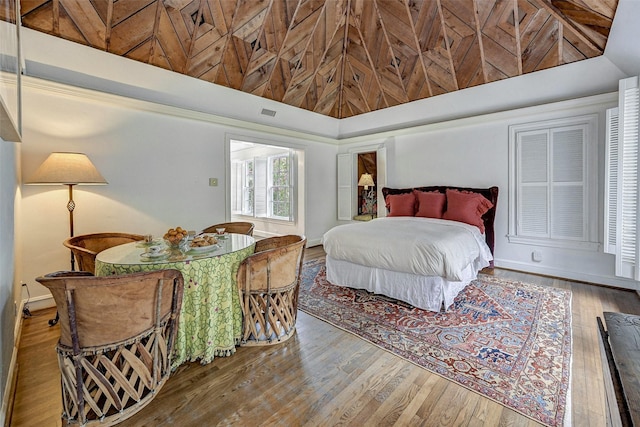 bedroom featuring hardwood / wood-style floors and high vaulted ceiling