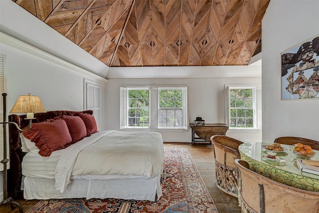 bedroom with a towering ceiling and hardwood / wood-style floors