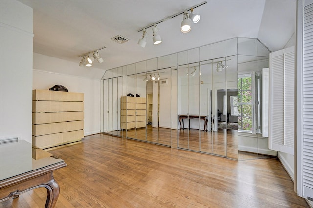 workout area with lofted ceiling and hardwood / wood-style flooring