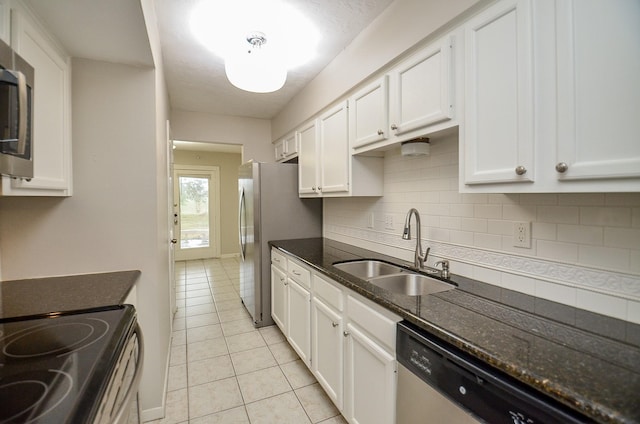 kitchen featuring white cabinetry, appliances with stainless steel finishes, sink, and dark stone countertops