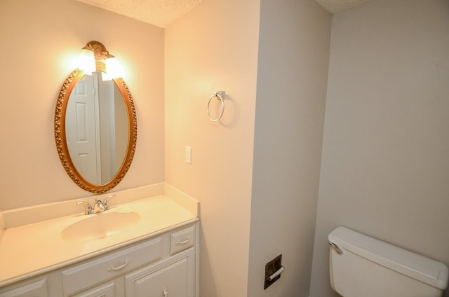 bathroom with vanity, a textured ceiling, and toilet