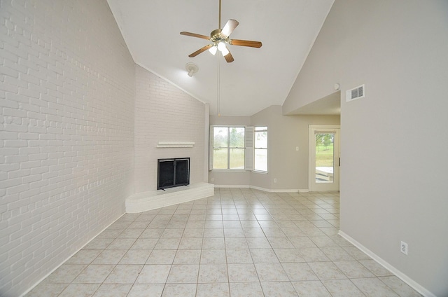 unfurnished living room featuring ceiling fan, high vaulted ceiling, brick wall, a brick fireplace, and light tile patterned flooring