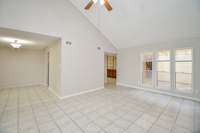 tiled spare room featuring ceiling fan, high vaulted ceiling, a textured ceiling, and brick wall