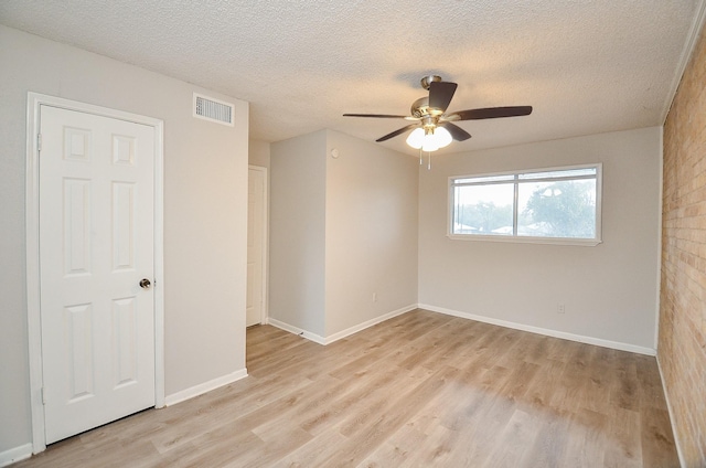 unfurnished room featuring ceiling fan, a textured ceiling, and light wood-type flooring