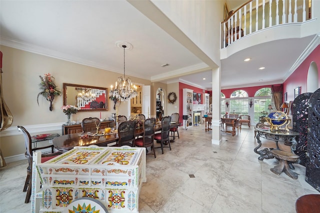 dining room featuring a fireplace, ornamental molding, and a chandelier