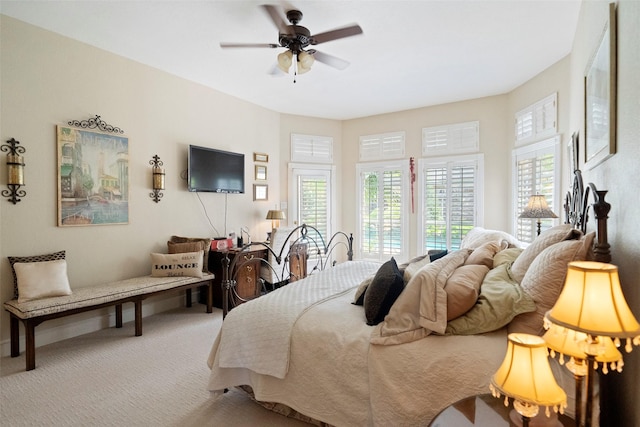 carpeted bedroom with multiple windows, access to outside, and ceiling fan